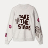 Productfoto van de grijze sweater plat gefotografeerd, met tekstprint en pailletdetails.