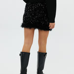 model draagt de riley rok van heyb club in zwart met pailetten en feax fur look.
