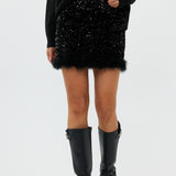 model draagt de riley rok van heyb club in zwart met pailetten en feax fur look.