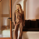 Model draagt beige shayma trouser met de donja blazer in zomerse setting als co-ord.