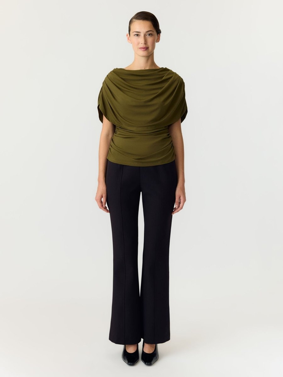 Model in olijfgroene cape top Y.A.S Drala met zwarte flared pantalon en pumps | Jo&Co Club