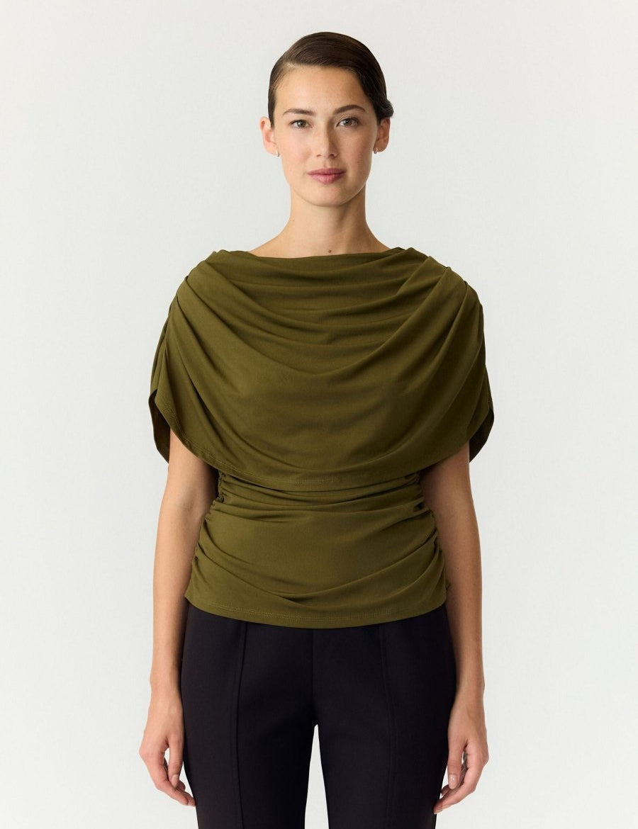 Cape top Y.A.S Drala in olijfgroen – model met boothals en gedrapeerde cape, op een zwarte pantalon | Jo&Co Club