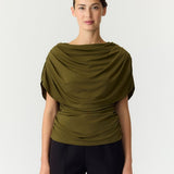 Cape top Y.A.S Drala in olijfgroen – model met boothals en gedrapeerde cape, op een zwarte pantalon | Jo&Co Club