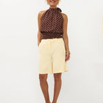 Model in halterneck polkadot top met smock-tailleband en soft yellow Bermuda Jolijn | Jo&Co Club