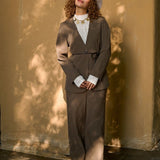 model draagt de ydence lexie blazer in de kleir mud met een zwart ceintuur en de yade pants in een zonnige herst achtige setting.