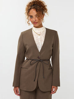 model draagt de ydence lexie blazer in de kleir mud met een zwart ceintuur.