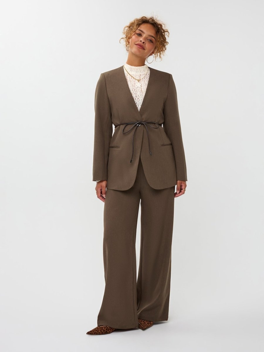 model draagt de ydence lexie blazer in de kleur mud met een zwart ceintuur. hieronder draagt ze de yade pants van ydence.