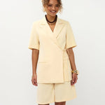 Model lachend frontaal in soft yellow Ydence Blazer Lucille met bermuda short als setje | Jo&Co Club