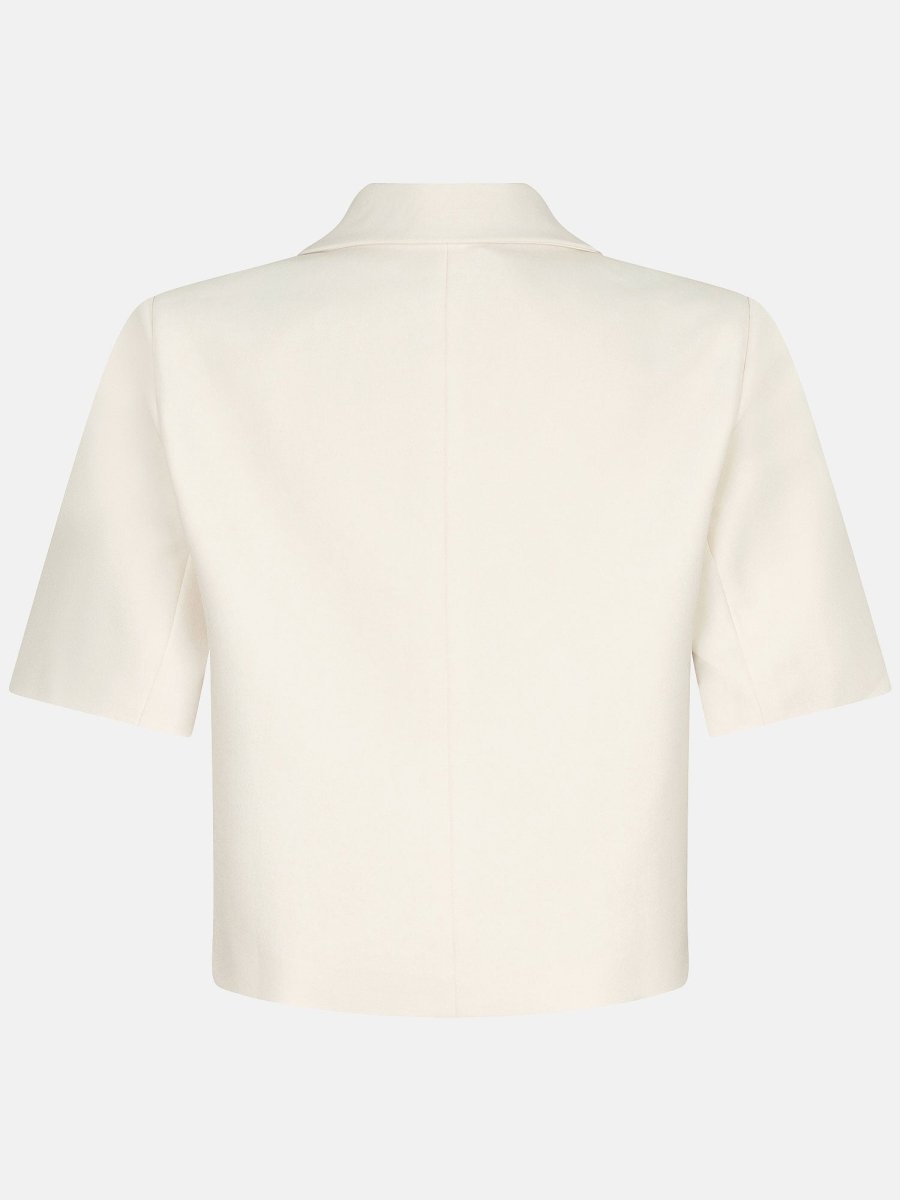 Een achterkant-aanzicht van een blazer-stijl top in een ecru kleur, gefotografeerd tegen een | Ydence Zella | Jo&Co Club