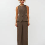 model draagt het mellie gilet van ydence in de kleur mud met de yade pants als co-ord set.