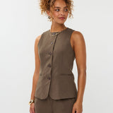 model draagt het mellie gilet van ydence in de kleur mud met de yade pants als co-ord set.