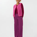 Model draagt het puck gilet van ydende van teddy stof in de kleur fuchsia over de knitted top devina.
