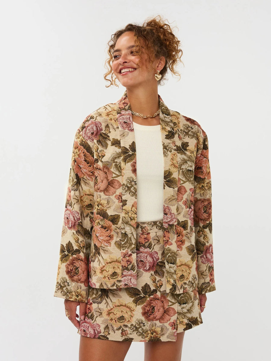 Model draagt de violette skort met bloemen print en de penny kimono als co-ord set.