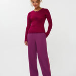 Model draagt de ydence knitted top devina met fuchsia en rode strepen.
