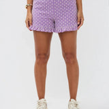 Model draagt de Larissa short, een paarse luchtige short met wit bloemenpatroon en rucherand van Ydence.