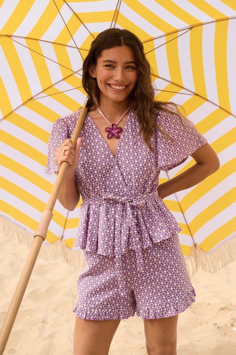 Campagnefoto van model met Ydence Larissa short en bijpassende Milay top onder een strandparasol.