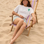 Model zittend op een strandstoel met het More Amore T-shirt van Ydence.