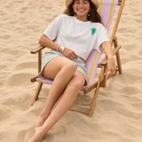 Model zittend op een strandstoel met het More Amore T-shirt van Ydence.