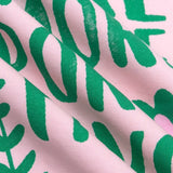 Detailopname van de roze en groene print op het T-shirt.