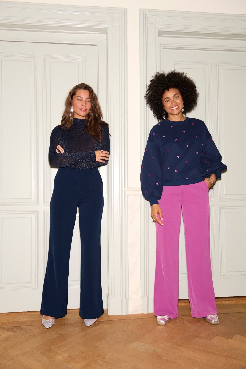 Modellen dragen de solange pants van ydence in kleuren roze en blauw, rechter model draagt ook de hearts sweater van ydence.
