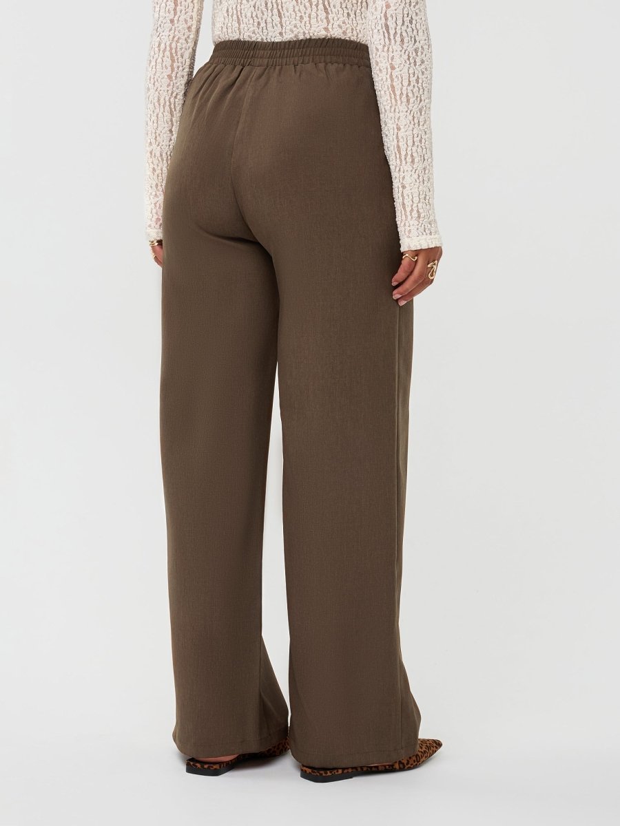 Model draagt de yade pants van ydence in de kleur mud, achter aanzicht.