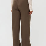 Model draagt de yade pants van ydence in de kleur mud, achter aanzicht.