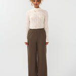 Model draagt de ydence yade pants in de kleur mud met een witte top.