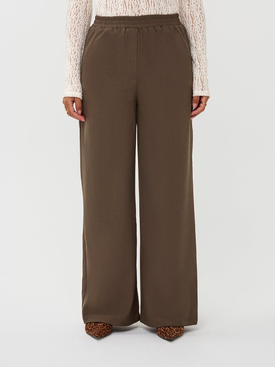 Model draagt de yade pants van ydence in de kleur mud, vooraanzicht.