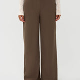 Model draagt de yade pants van ydence in de kleur mud, vooraanzicht.