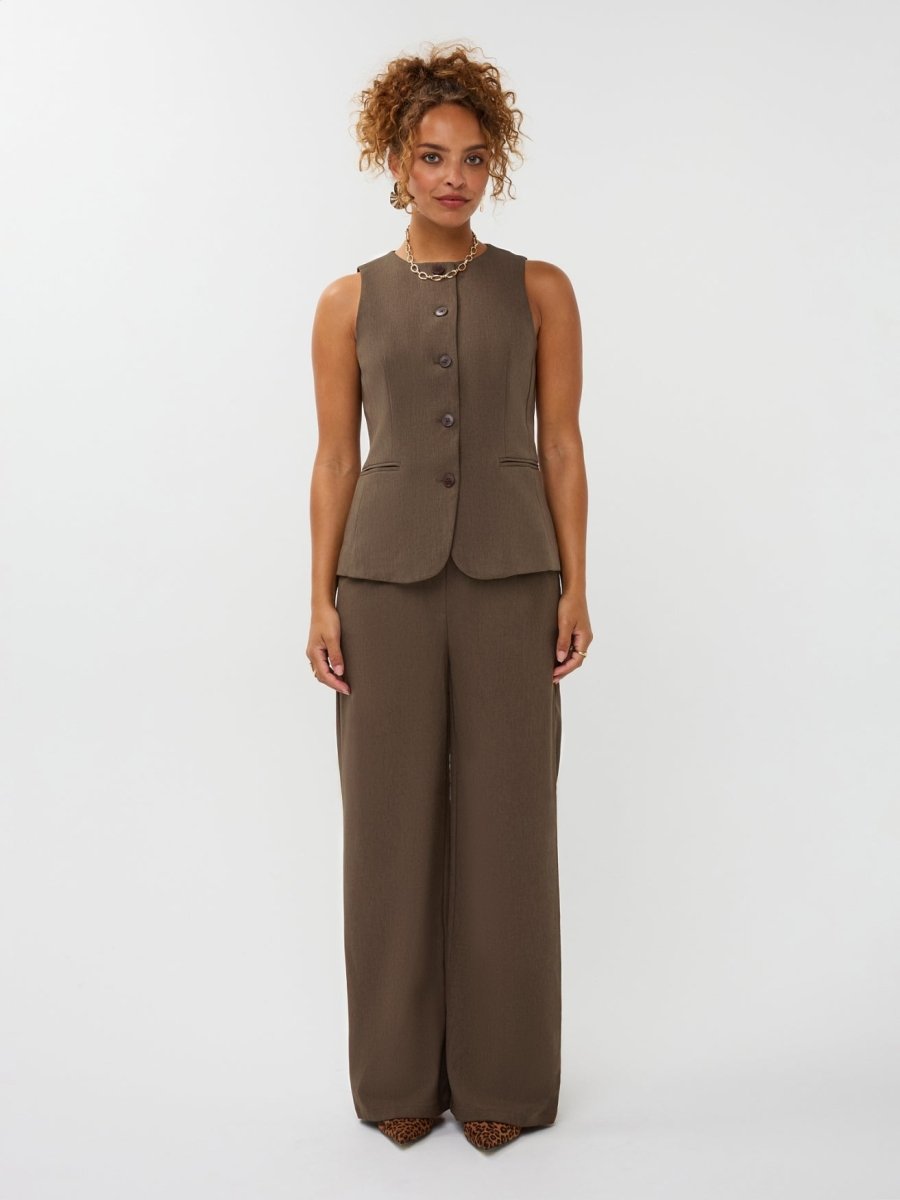 Model draagt de ydence yade pants gecombineerd met het mellie gilet in de kleur mud als co-ord set.