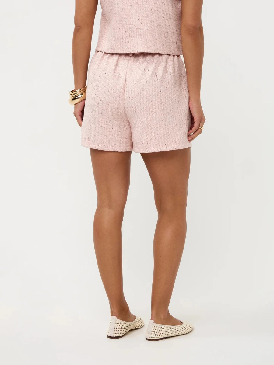 Een model, van achteren gefotografeerd, draagt een zachtroze short en een bijpassende top tegen | Ydence Harley | Jo&Co Club