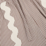 Dit is een detailopname van een kledingstuk met een zandkleurige en witte verticale streep | Ydence Isabel | Jo&Co Club