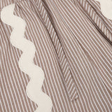Dit is een detailopname van een kledingstuk met een zandkleurige en witte verticale streep | Ydence Isabel | Jo&Co Club