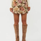 Model draagt de violette skort van ydencemet bloemenprint, voor zijde.