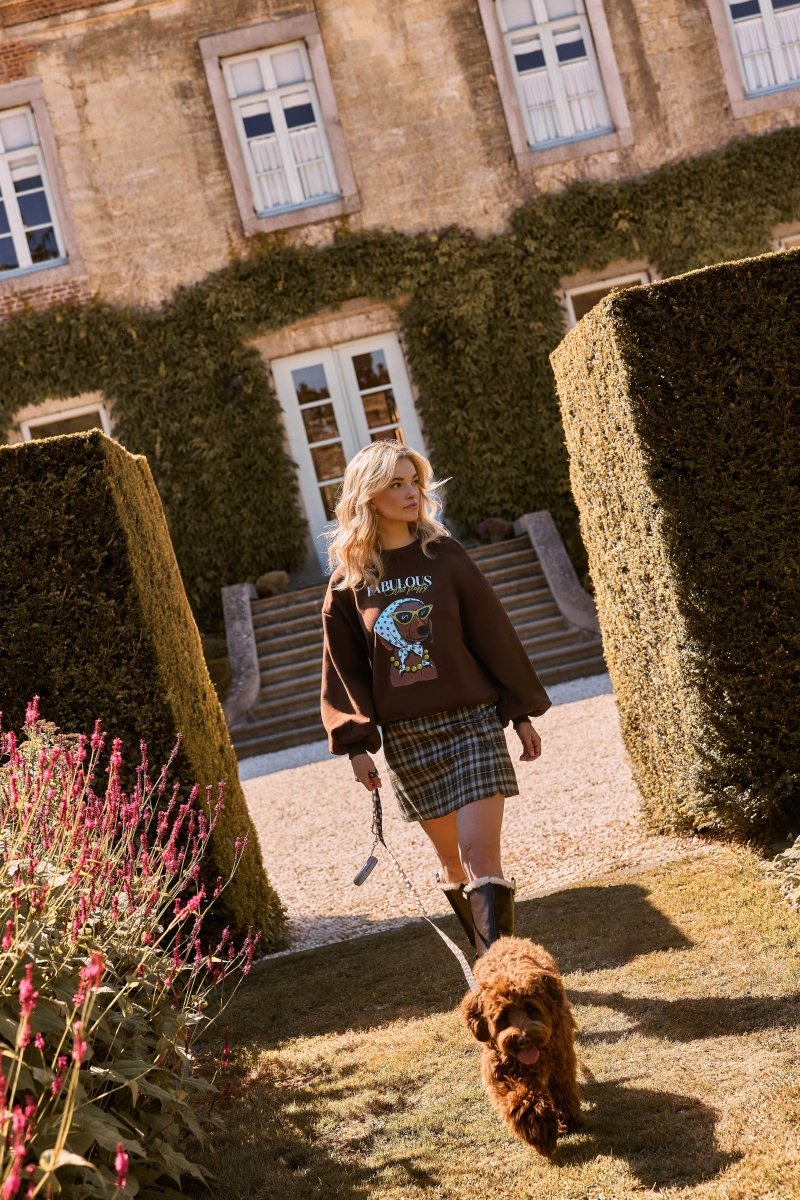 Model draagt de bruine Fabulous and fluffy trui buiten, met hond | Ydence Fabulous | Jo&Co Club