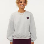 Model in grijze sweater met hartje en print op de rug Ydence Checked In | Jo&Co Club