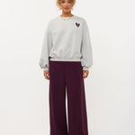 Model in grijze sweater met hartje en print op de rug Ydence Checked In | Jo&Co Club