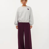 Model in grijze sweater met hartje en print op de rug Ydence Checked In | Jo&Co Club