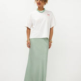 Model in oversized off-white Ydence Sunday mornings T-shirt met sage groene satijnen rok | Jo&Co Club