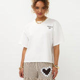 Model in oversized off-white Ydence Caffè T-shirt met gestreepte ruche-short, frontaal | Jo&Co Club