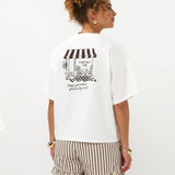 Lachend model van achteren in off-white Ydence Caffè T-shirt met cafédruk | Jo&Co Club