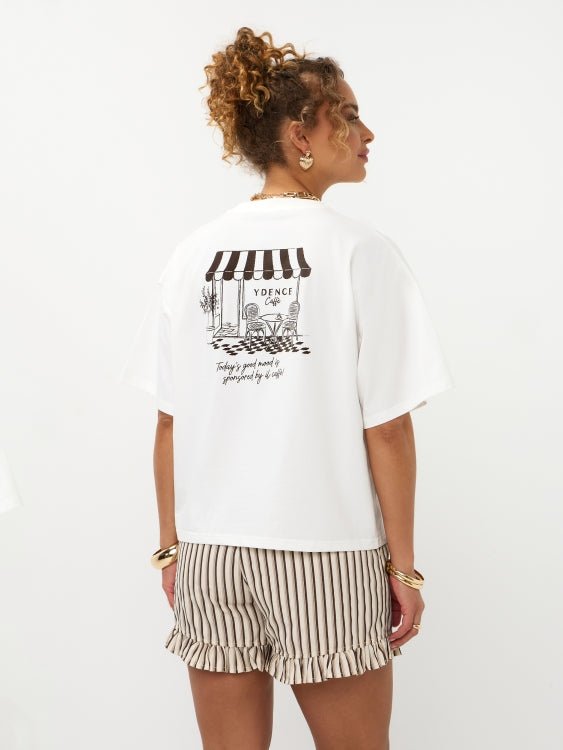 Lachend model van achteren in off-white Ydence Caffè T-shirt met cafédruk | Jo&Co Club