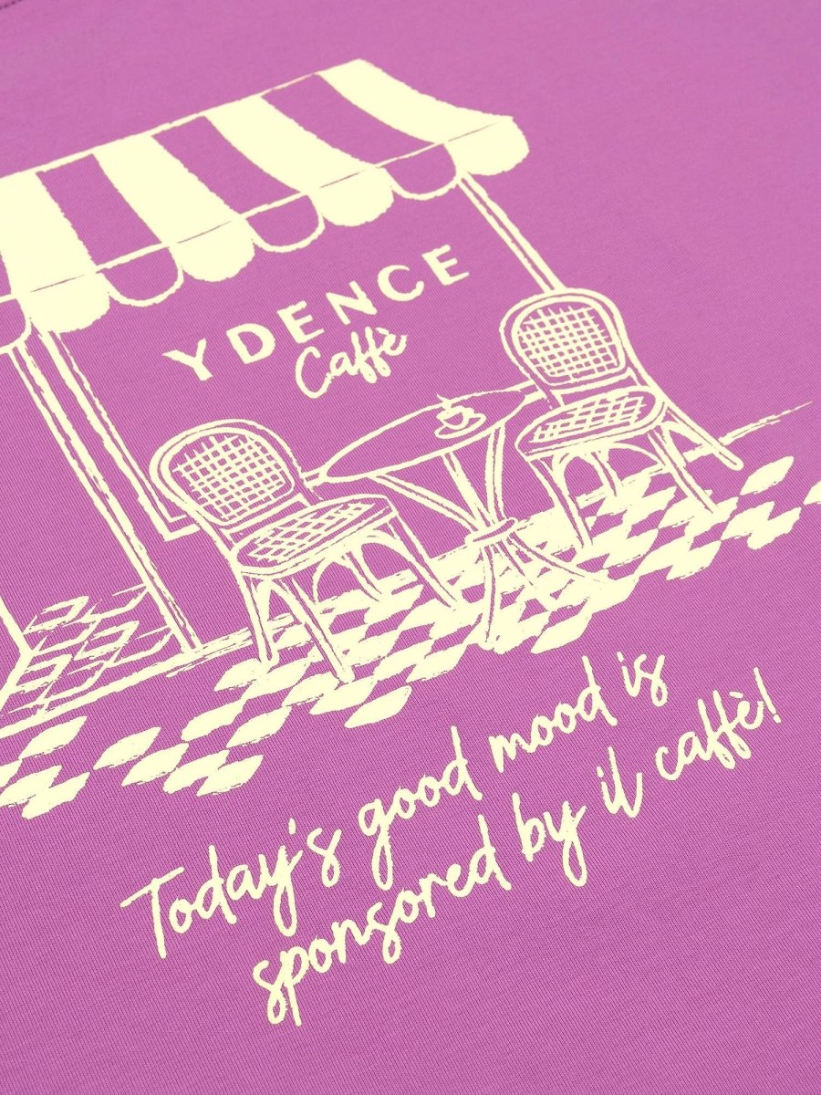 Een detailopname van een roze-paars T-shirt met een crèmekleurige grafische print | Ydence cafe | Jo&Co Club