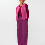 Model draagt het puck gilet van ydende van teddy stof in de kleur fuchsia over de knitted top devina.