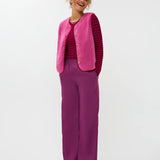 Model draagt het puck gilet van ydende van teddy stof in de kleur fuchsia over de knitted top devina.