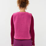 Model draagt het puck gilet van ydende van teddy stof in de kleur fuchsia over de knitted top devina.