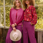 sfeer foto van het puck gilet van teddy stof in de kleur fuchsia samen met de ellie blouse in een natuurlijke setting.