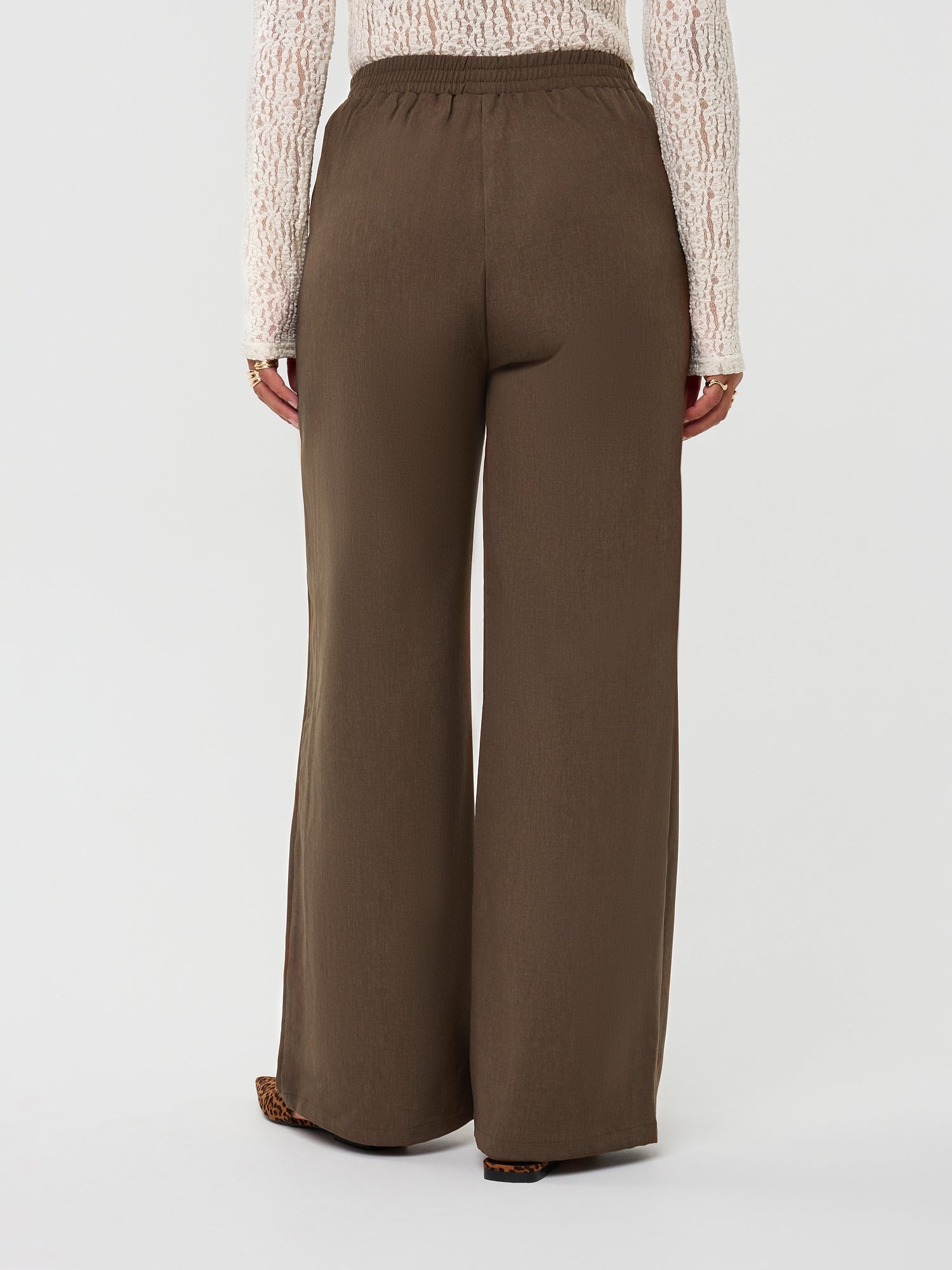 Model draagt de yade pants van ydence in de kleur mud, achter aanzicht.