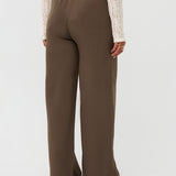 Model draagt de yade pants van ydence in de kleur mud, achter aanzicht.